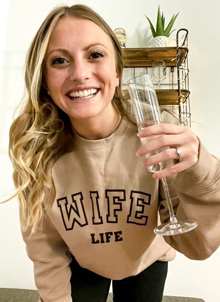 A woman in a brown “Wife Life” sweatshirt