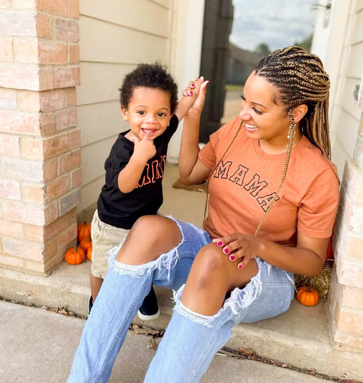 A mother and son wearing a mama-mini matching set in orange and black