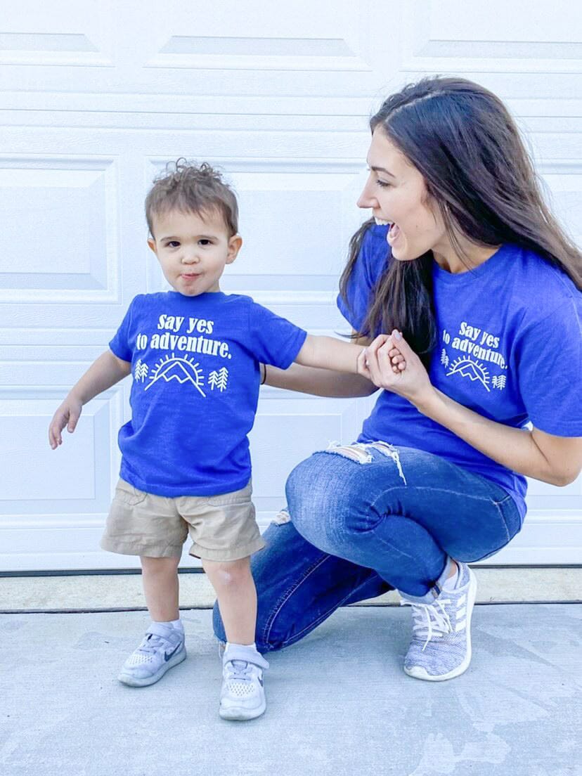 A mom and child sporting matching blue outdoorsy graphic tees