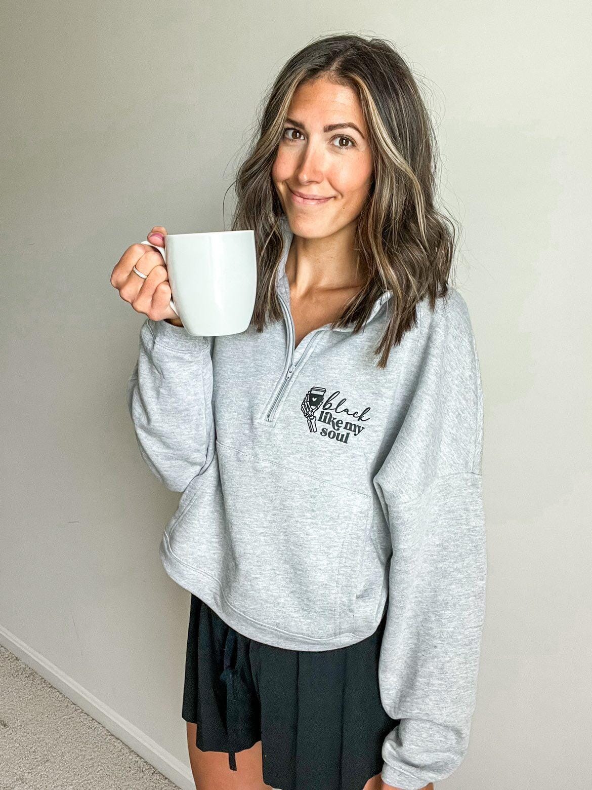 Woman in a gray coffee-themed sweatshirt